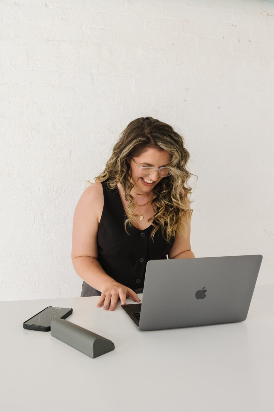 Kiah laughing while working at her laptop